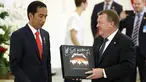 Perdana Menteri Denmark Lars Lokke Rasmussen memberikan Presiden Joko Widodo (Jokowi) cendera mata piringan hitam band Metallica usai pernyataan bersama dalam kunjungan kerja PM Denmark di Istana Bogor, Jawa Barat, Selasa (28/11). (AP/Dita Alangkara)