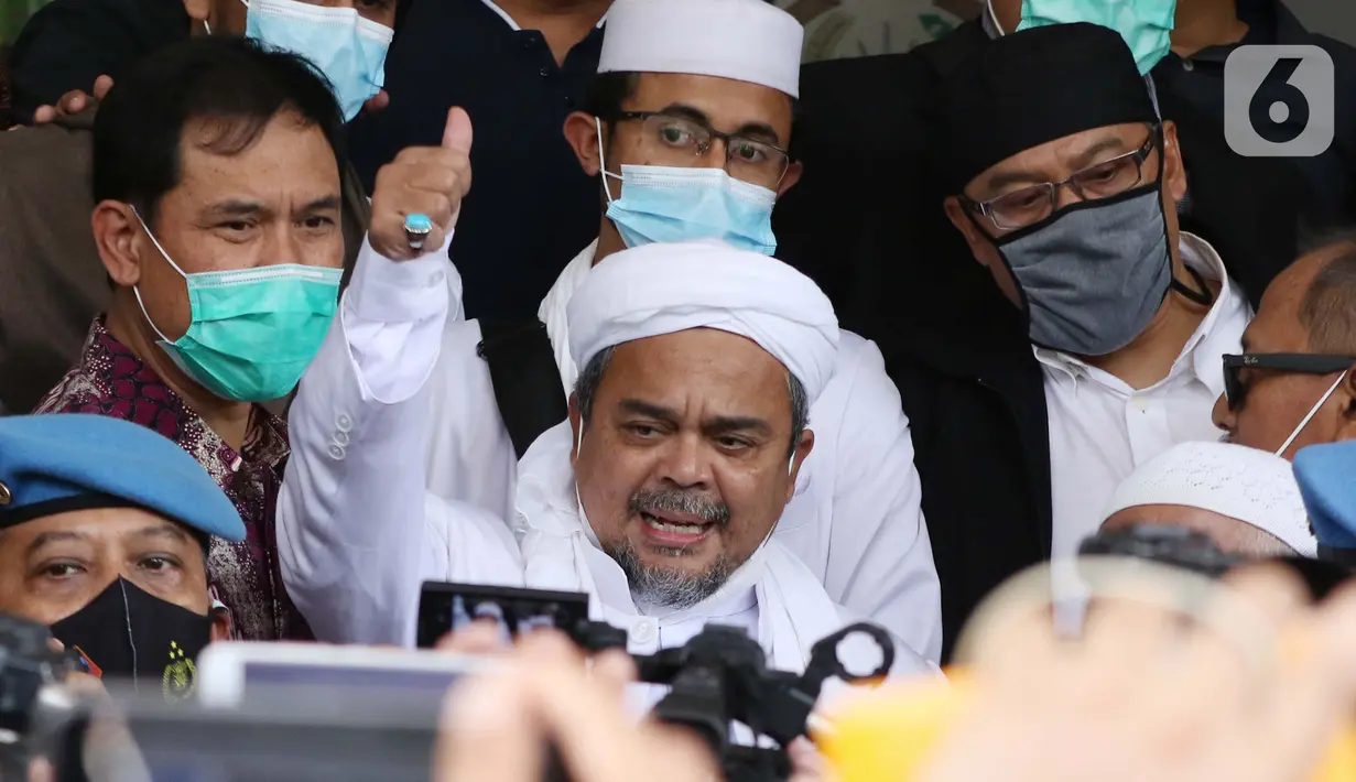 Rizieq Shihab (tengah) memberi keterangan sesaat sebelum masuk gedung utama Mapolda Metro Jaya, Jakarta, Sabtu (12/12/2020). Rizieq Shihab akan menjalani pemeriksan sebagai tersangka penghasutan dan kerumunan di tengah pandemi Covid-19. (Liputan6.com/Helmi Fithriansyah)
