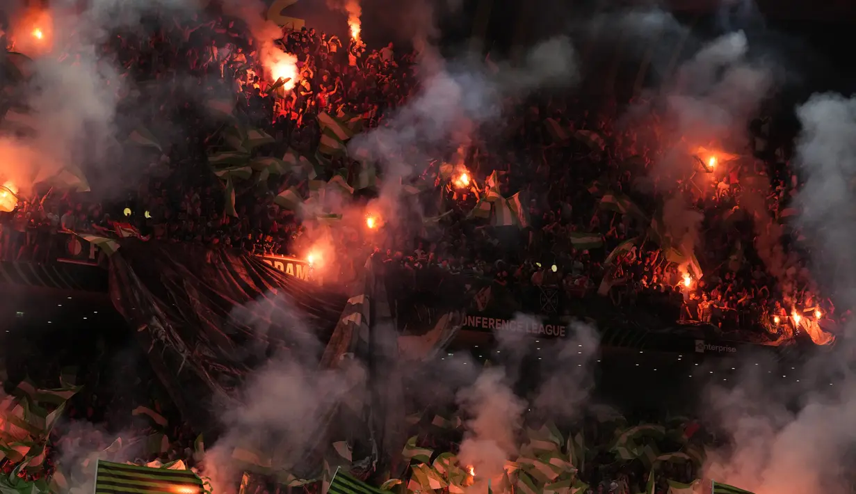 Fans menyalakan suar sebelum dimulainya pertandingan sepak bola final Liga Konferensi Eropa UECL musim 2021-222 antara AS Roma dan Feyenoord di Arena Kombetare, Tirana, Albania, Kamis (26/5/2022) dini hari WIB. AS Roma menjuarai UEFA Europa Conference League usai mengalahkan Feyenoord 1-0 lewat gol Nicolo Zaniolo. (AP Photo/Thanassis Stavrakis)