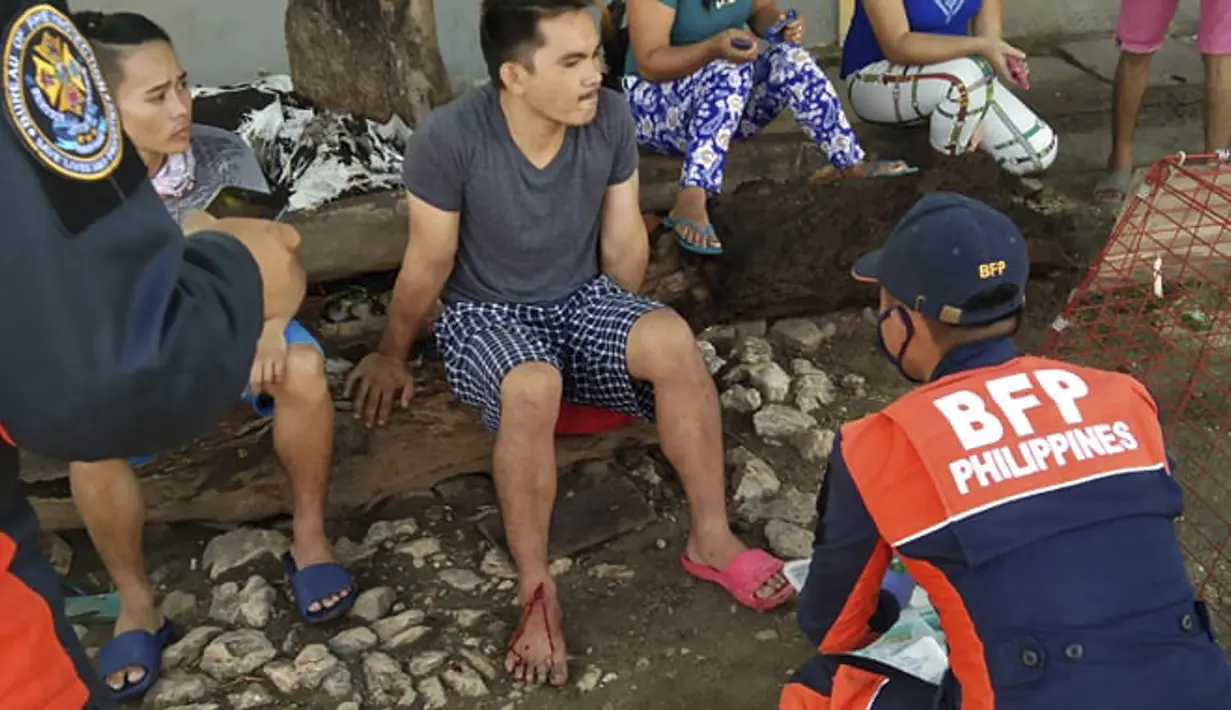 Seorang pria yang terluka dirawat setelah gempa bumi yang kuat melanda Cataingan, provinsi Masbate, Filipina tengah (18/8/2020). (AP Photo/ Christopher Decamon)