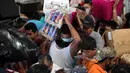 Seorang warga membawa minuman usai menjarah sebuah toko di Veracruz, Meksiko, (5/1). Kepolisian menyebut sebanyak 300 toko digeledah dan lebih dari 600 orang ditangkap. (AP Photo/Felix Marquez)