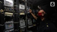 Petugas memeriksa meteran listrik di Rusun Bendungan Hilir, Jakarta, Rabu (7/4/2021).  Lewat program Ramadan Peduli, pelanggan rumah tangga daya 450 VA sampai dengan 7.700 VA dapat membeli produk Renewable Energy Certificate (REC) sebesar Rp 115.500. (Liputan6.com/Johan Tallo)