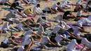 Peserta melakukan gerakan yoga selama latihan di gurun Samalayuca, negara bagian Chihuahua, Meksiko, 28 April 2018. Latihan di atas pasir gurun yang terik ini menjadi tantangan tersendiri bagi para pencinta Yoga. (AFP PHOTO / HERIKA MARTINEZ)