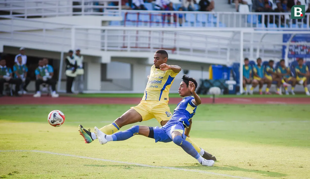 Bek kiri Arema FC, Johan Alfarizi menjuauhkan bola dari kejaran striker Persib Bandung, Uilliam Barros dalam laga pekan keenam BRI Super League 2025/2026 di Stadion Kanjuruhan, Kabupaten Malang, Senin (22/9/2025). (Bola.com/Iwan Setiawan).