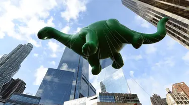 Balon raksaksa berbentuk Dino Saurus ikut meramaikan Parade Thanksgiving Day di New York City (26/11/2015). Beragam balon raksaksa yang dibuat seperti tokoh animasi menjadi suguhan utama dalam perayaan tersebut. (AFP Photo/Timothy A. Clary)