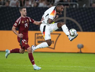 Bek Jerman Jonathan Tah menendang bola saat penyerang Hungaria Barnabas Varga mencoba menghentikannya pada ertandingan pertama grup C UEFA Nations League 2024,, Minggu (8/9/2024) dini hari WIB. (AP Photo/Michael Probst)