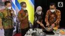 Dirut Bank BTN Haru Koesmahargyo (kanan) memasak menggunakan kompor induksi dalam acara Ayo Investasi Properti di Kawasan Transit Oriented Development (TOD) dan Launching KPR/KPA Platinum Bundling Kompor Induksi Bersama Bank BTN di Jakarta, Rabu (28/4/2021). (Liputan6.com/Pool/BTN)