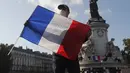 Seorang demonstran memegang bendera Prancis dengan slogan "Freedom of Speech" selama demonstrasi di Paris (18/10/2020). Pembunuh Samuel merupakan pria kelahiran Moskow berusia 18 tahun yang ditembak mati oleh polisi. (AP Photo/Michel Euler)