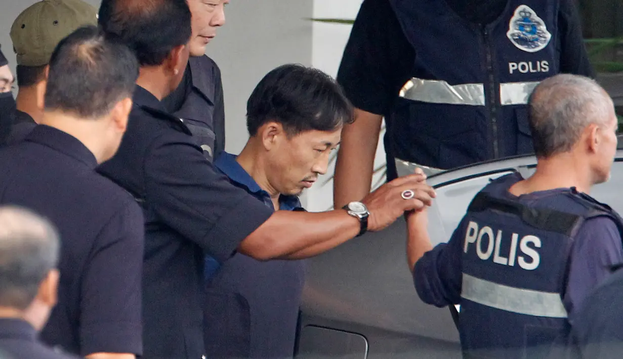 WN Korut Ri Jong Chol (kedua kanan) terunduk saat meninggalkan markas Polisi Sepang, Malaysia, Jumat (3/3). Ri Jong Chol merupakan satu-satunya orang berkebangsaan Korut yang ditangkap terkait kasus pembunuhan Kim Jong-nam. (AP Photo/Daniel Chan)