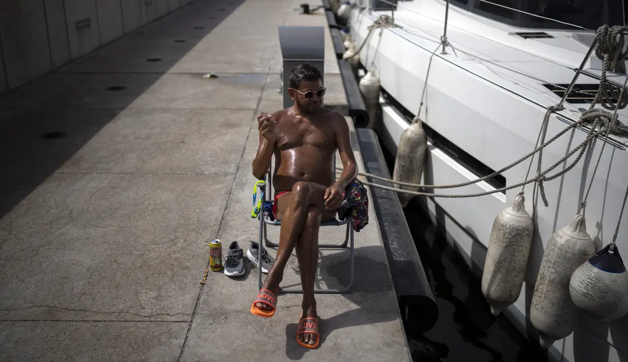 Seorang pria berjemur saat gelombang panas di Marseille, Prancis, 15 Juni 2022. (AP Photo/Daniel Cole)