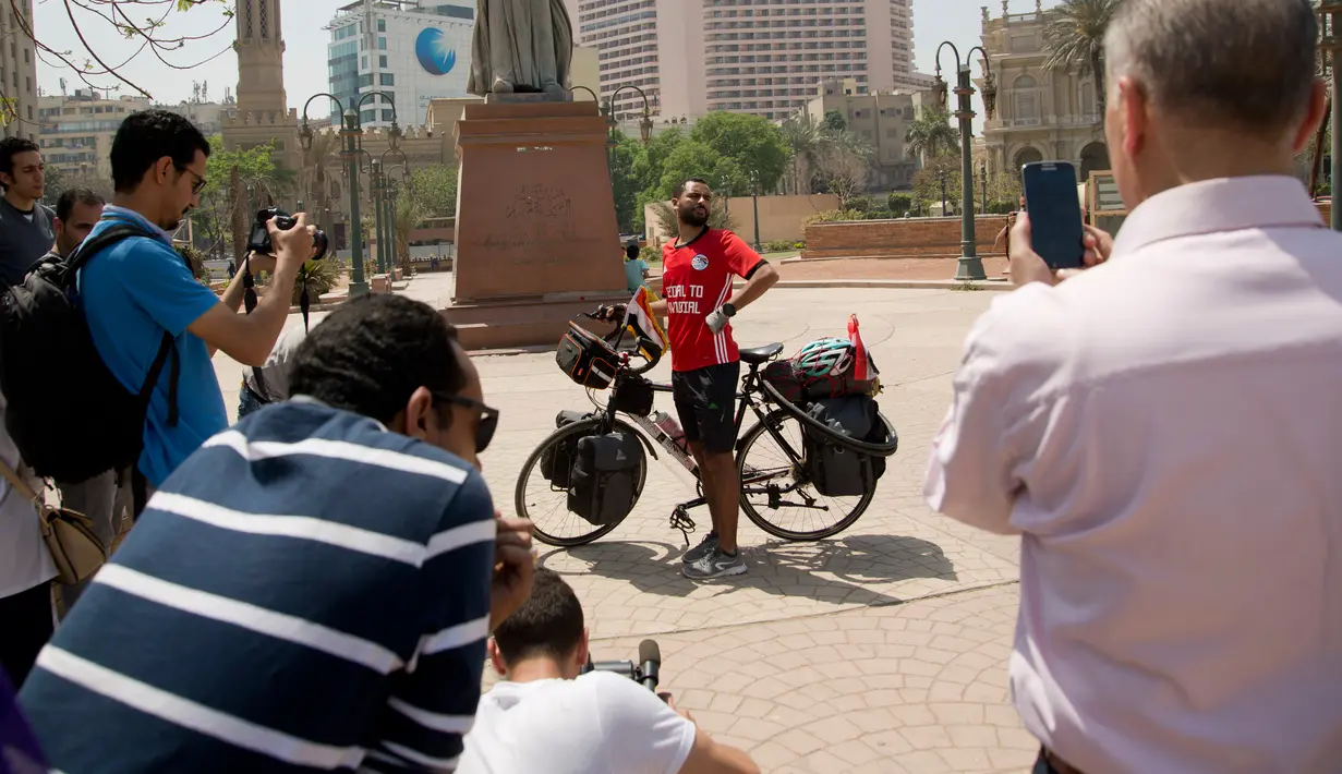Pria Mesir, Mohammed Nufal berpose sebelum menuju Rusia menggunakan sepeda dari Tahrir Square di Kairo, Sabtu (7/4). Nufal menempuh jarak ribuan kilometer untuk melihat Timnas Mesir bertanding di Piala Dunia setelah absen selama 28 tahun. (AP/Amr Nabil)