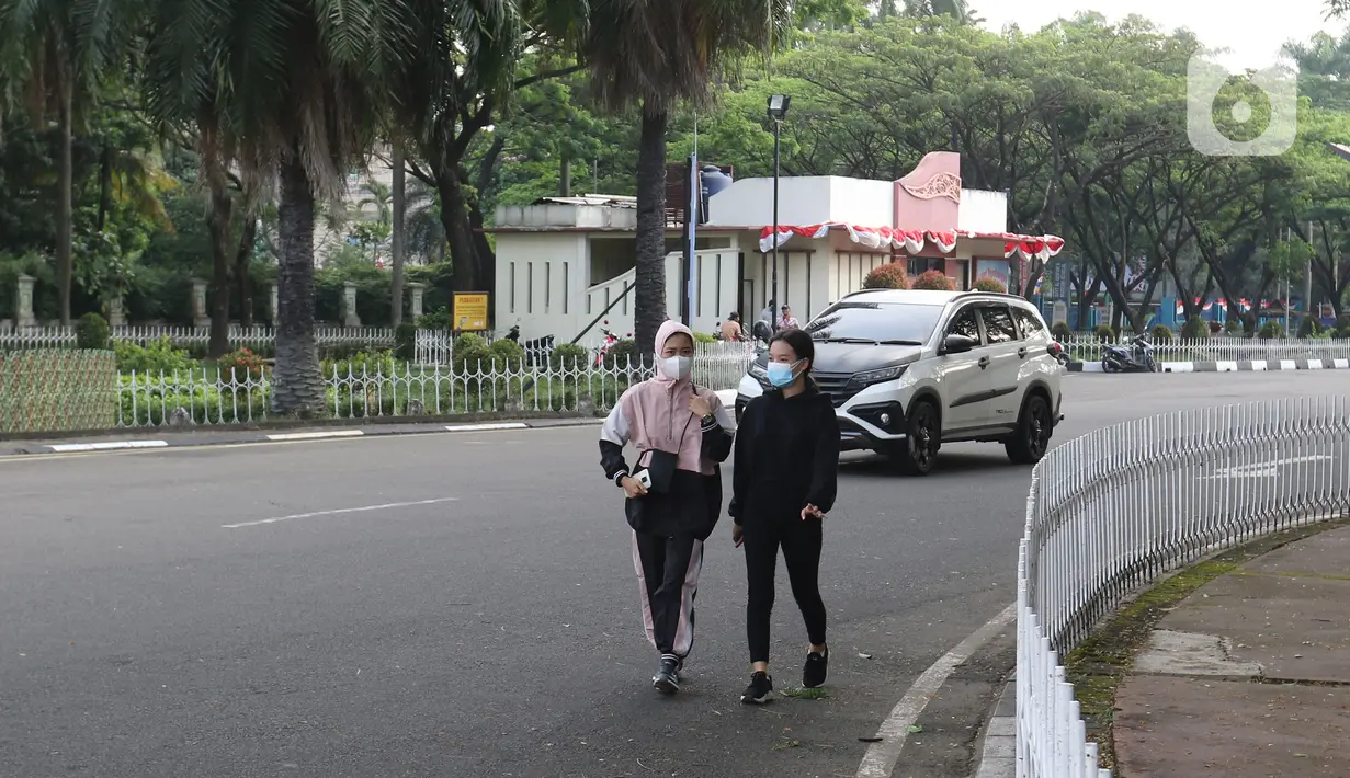 Warga berolahraga sore di kawasan Taman Mini Indonesia Indah, Jakarta, Minggu (22/8/2021). TMII kembali dibuka mulai 06.00-18.00 WIB namun terbatas hanya untuk kegiatan berolahraga outdoor atau luar ruangan dan dengan syarat menunjukkan sertifikat vaksinasi covid-19. (Liputan6.com/Herman Zakharia)