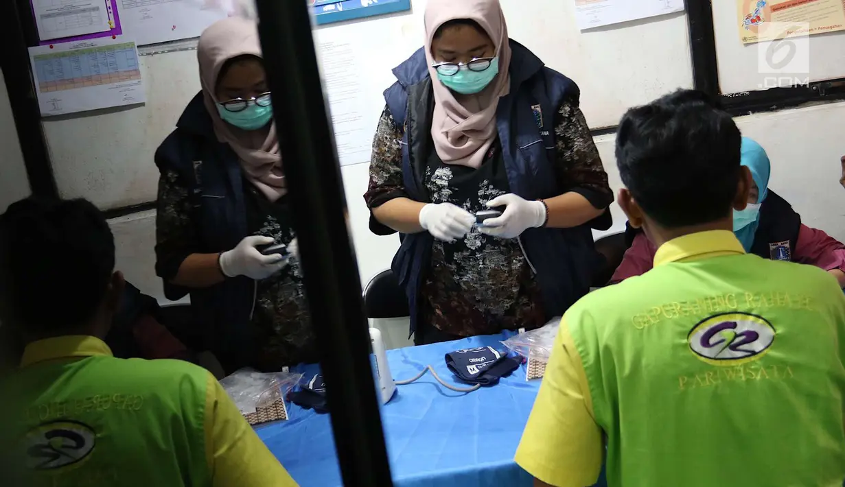 Petugas memeriksa kesehatan sopir bus di Terminal Kampung Rambutan, Jakarta, Jumat (8/6). Pemeriksaan bertujuan memastikan kondisi kesehatan sopir agar tetap baik dalam mengoperasikan kendaraan yang mengangkut pemudik. (Liputan6.com/Immanuel Antonius)