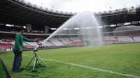 Pekerja menyemprot rumput lapangan Stadion Gelora Bung Karno pasca renovasi, Jakarta, Jumat (12/1). Rencananya, Stadion GBK akan diresmikan penggunaannya pasca renovasi oleh Presiden Joko Widodo, Minggu (14/1). (Liputan6.com/Helmi Fithriansyah)