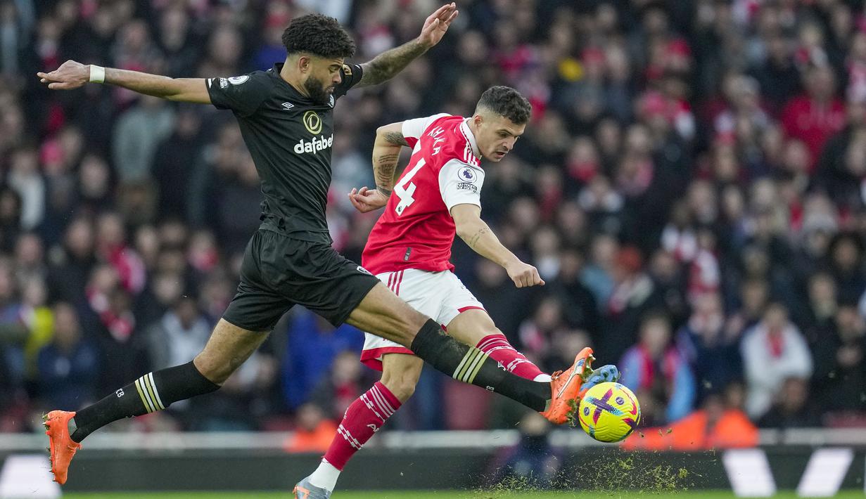 Pemain Bournemouth, Philip Billing (kiri) berusaha merebut bola dari pemain Arsenal, Granit Xhaka pada laga pekan ke-26 Liga Inggris 2022/2023 yang berlangsung di Emirates Stadium, London, Sabtu (04/03/2023). Bournemouth kalah dengan skor 2-3 dari Arsenal pada laga yang berjalan alot tersebut. (AP Photo/Kin Cheung)