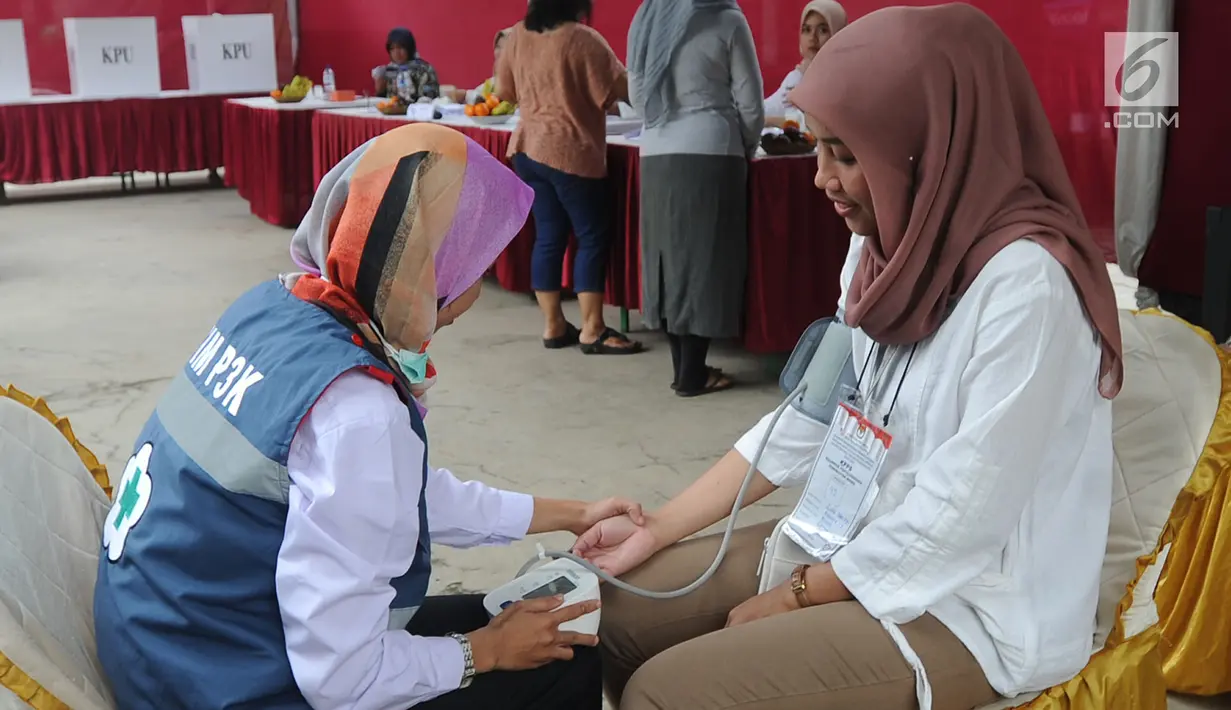 Petugas Kelompok Penyelenggara Pemungutan Suara (KPPS) menjalani pemeriksaan kesehatan oleh petugas medis Puskesmas saat pemungutan suara ulang di TPS 49 Rengas, Ciputat Timur, Tangsel, Rabu (24/4). Pemeriksaan untuk antisipasi menurunnya kesehatan fisik akibat kelelahan. (merdeka.com/Arie Basuki)