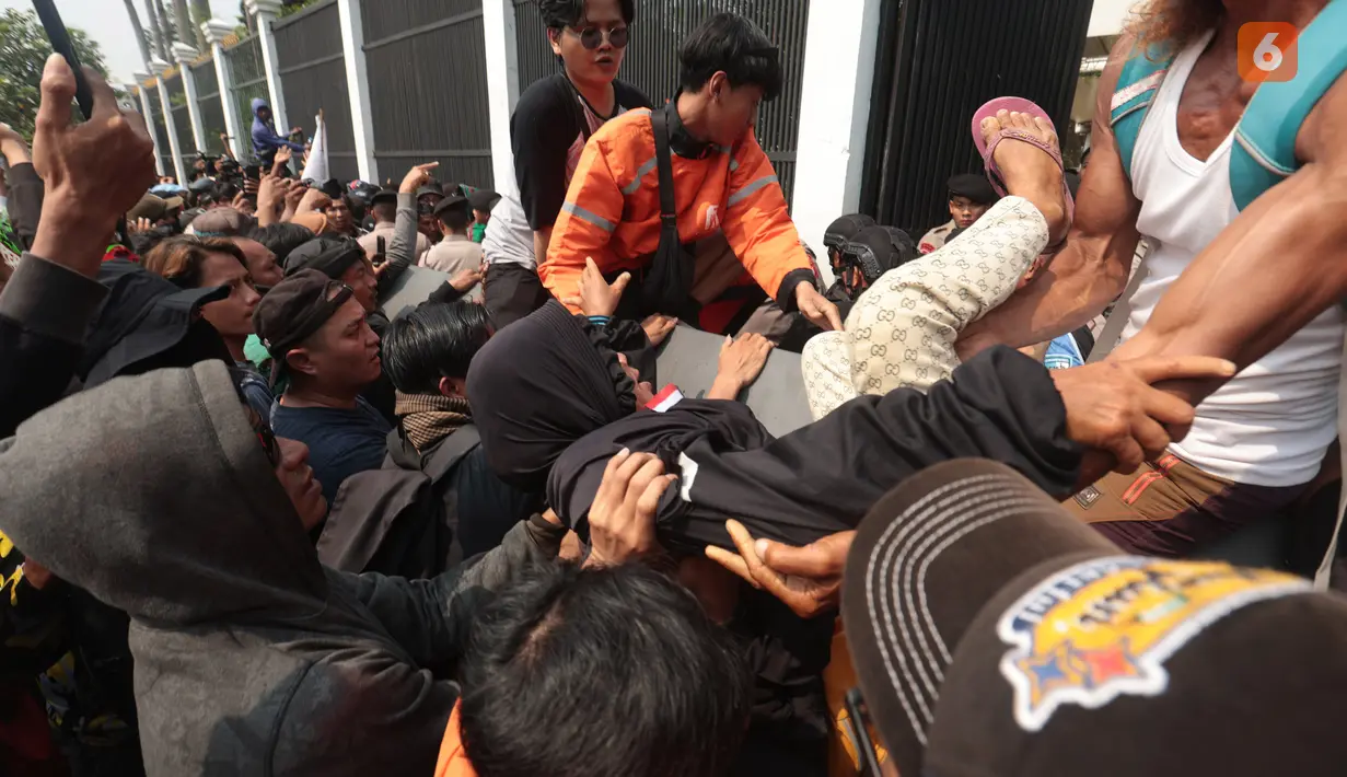 Seorang pendemo berusaha masuk ke kompleks gedung DPR melalui pintu kecil di sisi gedung, namun dihadang petugas kepolisian saat aksi Aliansi Masyarakat Pati Bersatu (AMPB) di Jakarta, Kamis (27/8/2026). (KLY/Budy Santoso)