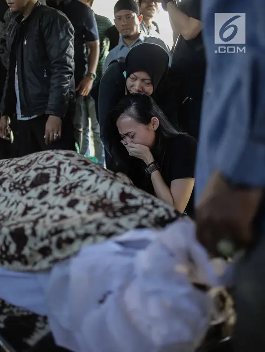 Kekasih almarhum Andika Putra Sahadewa, Nicky Santoso menangis di dekat makam di TPU Sunan Giri, Rawamangun, Jakarta, Selasa (10/9). Bassist grup band Kerispatih, Andika Putra Sahadewa, meninggal dunia di usia 36 tahun. (Liputan6.com/Faizal Fanani)