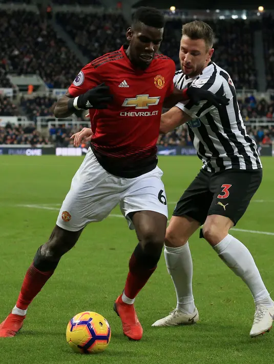 Gelandang Manchester United, Paul Pogba mengontrol bola dari kawalan pemain Newcastle United, Paul Dummett selama pertandingan lanjutan Liga Inggris di St James 'Park (2/1). MU menang 2-0 atas Newcastle. (AFP Photo/Lindsey Parnaby)