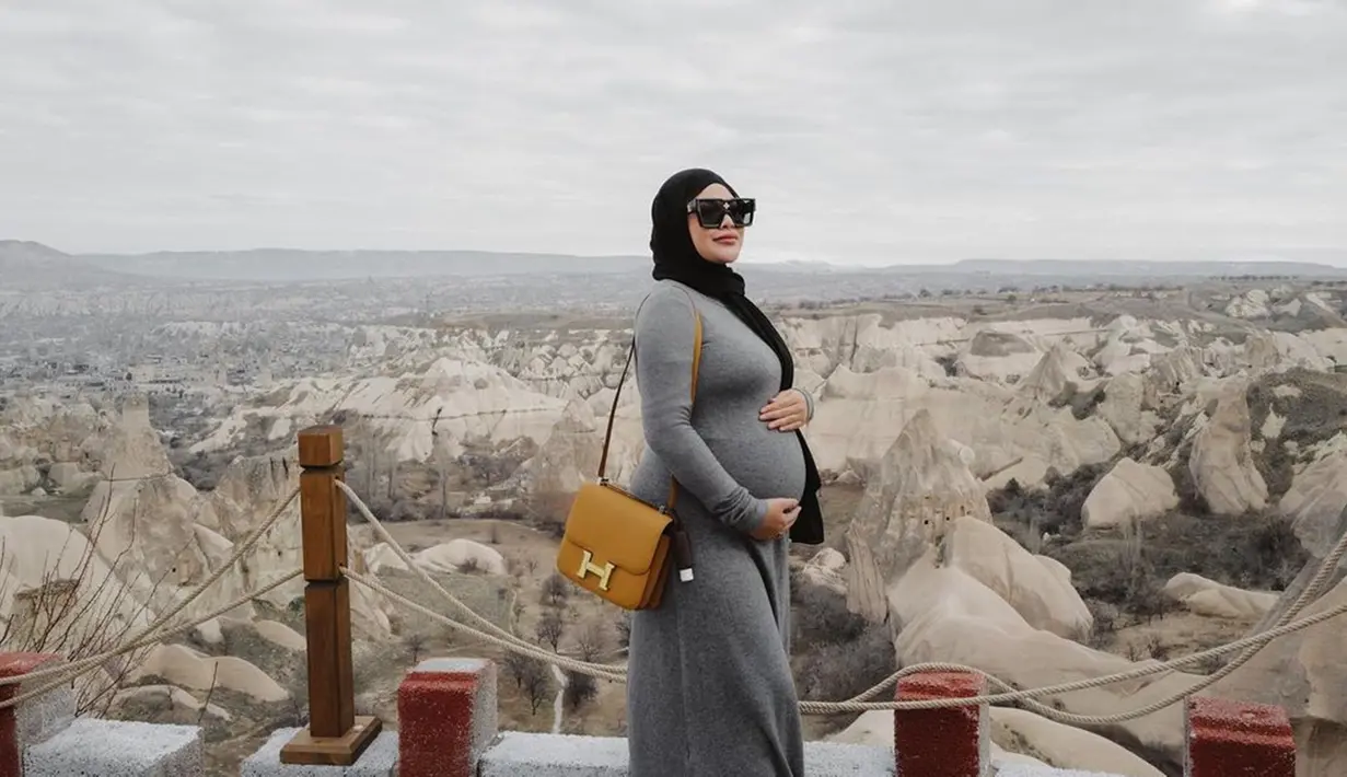 Gaya OOTD Aurel Hermansyah saat tengah liburan di Cappadocia ini tak lepas dari perhatian netizen. Tampil dengan dress abu-abu kala waktu hamil Ameena, pesona cantik Aurel kian terpancar. Mengenakan kacamata hitam, membuat wanita 24 tahun itu terlihat begitu menawan.(Liputan6.com/IG/@aurelie.hermansyah)