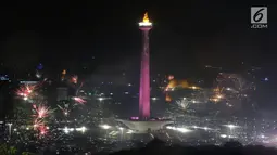 Kembang api menyala menyambut pergantian tahun 2018 ke 2019 di kawasan Monumen Nasional, Jakarta, Selasa (1/1). Hujan yang mengguyur Jakarta tidak menyurutkan warga menikmati kembang api tahun baru. (Liputan6.com/Helmi Fithriansyah)