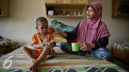 Seorang anak diberi minum di rumah singgah Yayasan Kasih Anak Kanker Indonesia, Jakarta, Senin (15/2). Setiap hari 700 anak terdiagnosis kanker Hal ini menunjukkan kanker sebagai penyebab utama kematian pada anak di dunia. (Liputan6.com/Faizal Fanani)