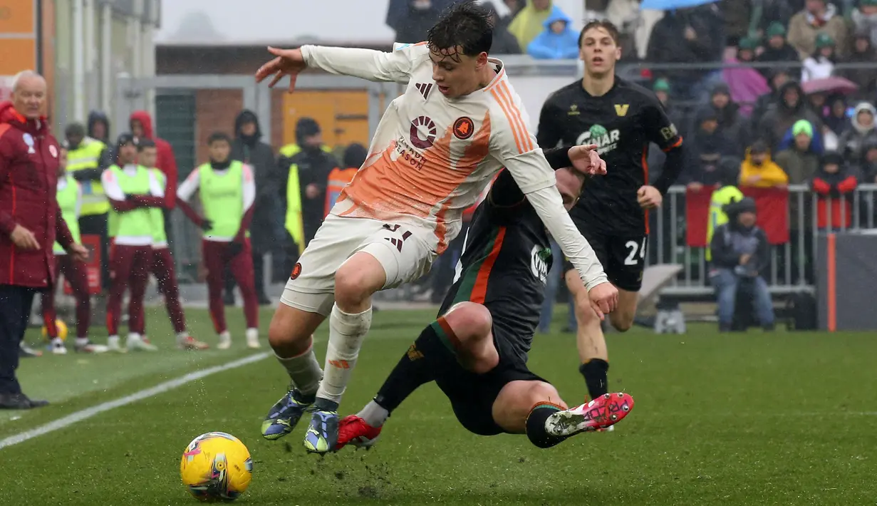 Pemain AS Roma, Paulo Dybala (kiri) berebut bola dengan pemain Venezia, Hans Nicolussi Caviglia dalam laga lanjutan Liga Italia 2024/2025 di Pier Luigi Penzo Stadium, Venice, Italia, Minggu (10/02/2025). (AP Photo/LaPresse/Paola Garbuio)