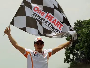 Juara Dunia MotoGP 2013 dan 2014, Marc Marquez membentangkan bendera start di Sirkuit Sentul, Bogor, (21/10/2014). (Liputan6.com/Helmi Fithriansyah)