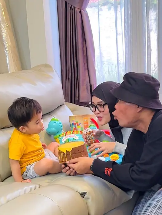 Adzam yang berusia dua tahun itu tingkahnya makin menggemaskan. Tampak, Adzam mengikuti ayahnya saat akan tiup lilin. Meski sederhana, tetap hangat dan penuh kesan. [Instagram/putridelinaa]