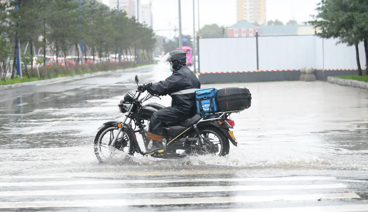 Pengendara motor menerjang genangan usai hujan deras akibat Topan Haishen di Changchun, Provinsi Jilin, China, 8 September 2020. Hujan deras yang dipicu Topan Haishen diperkirakan terjadi di sejumlah besar kawasan China timur laut selama dua hari ke depan. (Xinhua/Yan Linyun)