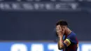 Striker Barcelona, Lionel Messi, menutup wajahnya usai ditaklukkan Bayern Munchen pada laga perempat final Liga Champions di Estadio da Luz, Sabtu (15/8/2020). Barcelona takluk 2-8 dari Bayern Munchen. (Manu Fernandez/POOL/AFP)