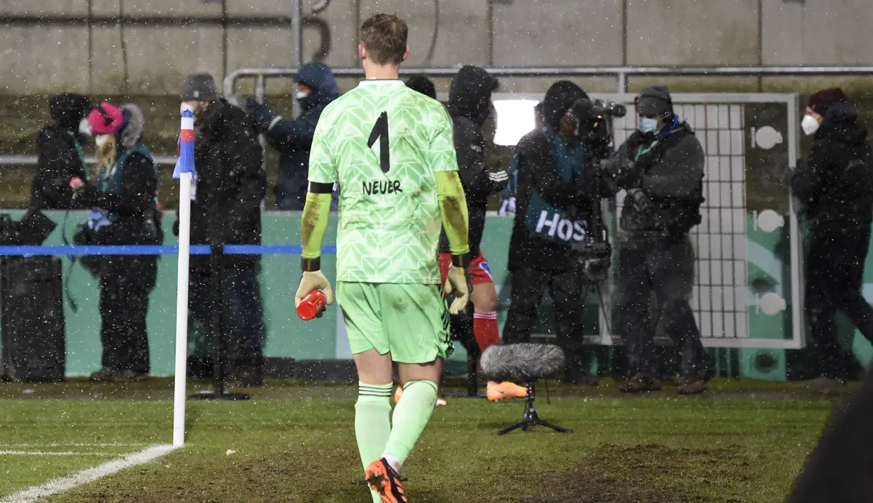 Kiper Bayern Munich, Manuel Neuer meninggalkan lapangan usai dikalahkan tim Divisi 2 Holstein Kiel 5-6 lewat adu penalti dalam laga babak kedua Piala DFB Pokal 2020/21 di Kiel, Rabu (13/1/2021). Kedua tim bermain imbang 2-2 di waktu normal hingga perpanjangan waktu. (AFP/Fabian Bimmer/Pool)
