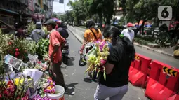 Warga membelii bunga hias di Pasar Petak Sembilan, Glodok, Jakarta, Senin (31/1/2022). Jelang tahun baru Imlek 2573 sejumlah bunga seperti sedap malam, aster, mawar dan lainnya mulai banyak dicari warga Tionghoa untuk sembahyang. (Liputan6.com/Faizal Fanani)