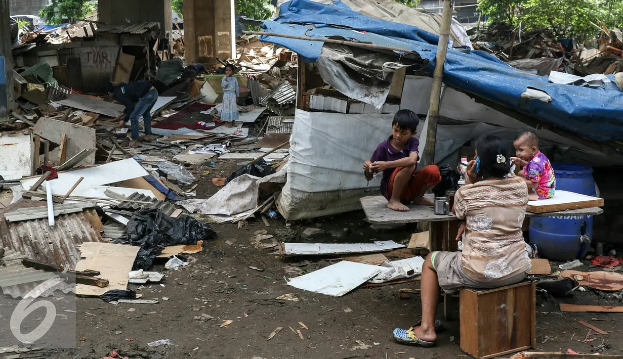 Penghuni kolong tol pluit makan bersama keluarga untuk terakhir kali di gubuk kayu tempat mereka berlindung, Jakarta, Rabu (2/3). Pemprov DKI membongkar 385 bangunan berdasarkan Perda No 8 Tahun 2007 tentang ketertiban umum. (Liputan6.com/Yoppy Renato)