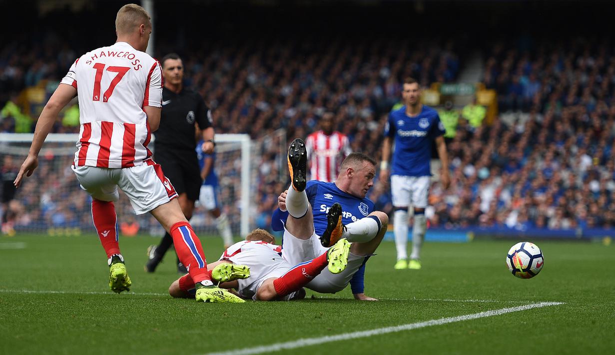 Wayne Rooney saat berebut bola dengan pemain Stoke City, Darren Fletcher (2kiri) pada laga perdana Premier League 2017-2018 di Goodison Park, Liverpool (12/8/2017). Everton menang 1-0. (AFP/Oli Scarff)