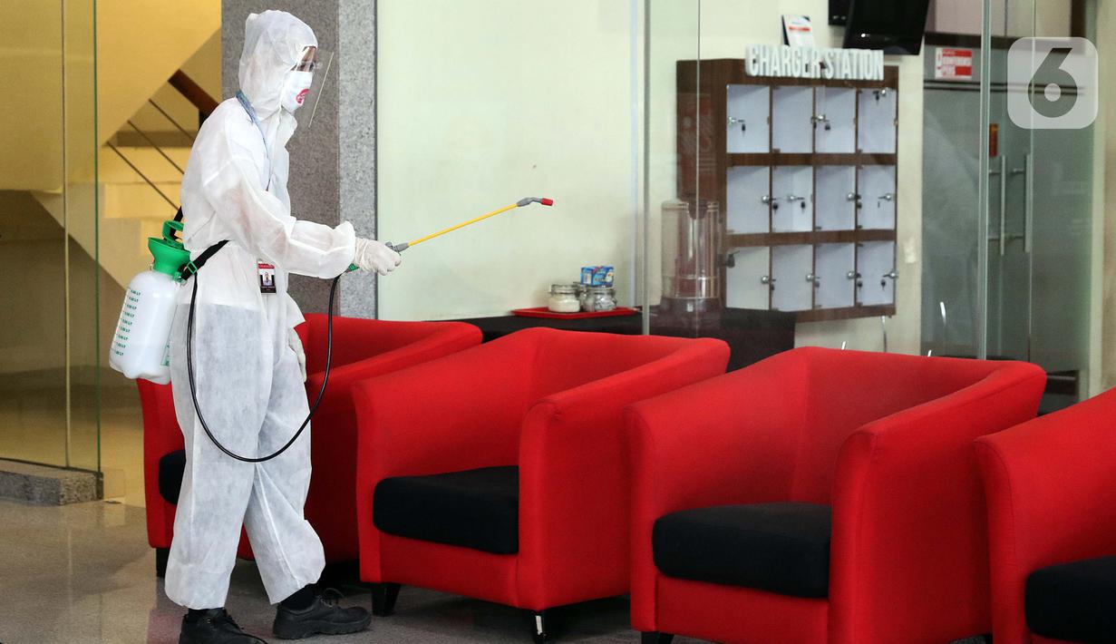 Petugas menyemprotkan cairan disinfektan di Gedung KPK, Jakarta, Selasa (22/9/2020). Penyemprotan dilakukan secara rutin untuk mengantisipasi serta menekan penyebaran virus COVID-19 menyusul temuan sedikitnya 21 kantor kementerian/lembaga yang menjadi klaster baru. (Liputan6.com/Helmi Fithriansyah)