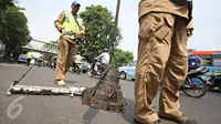 Tim Saber membersihkan Jalan Kyai Tapa, Jakarta, dari ranjau paku, Jumat (6/11). Kegiatan ini dilakukan untuk membersihkan jalan dari ranjau paku yang disebarkan oknum tak bertanggung jawab. (Liputan6.com/Immanuel Antonius)