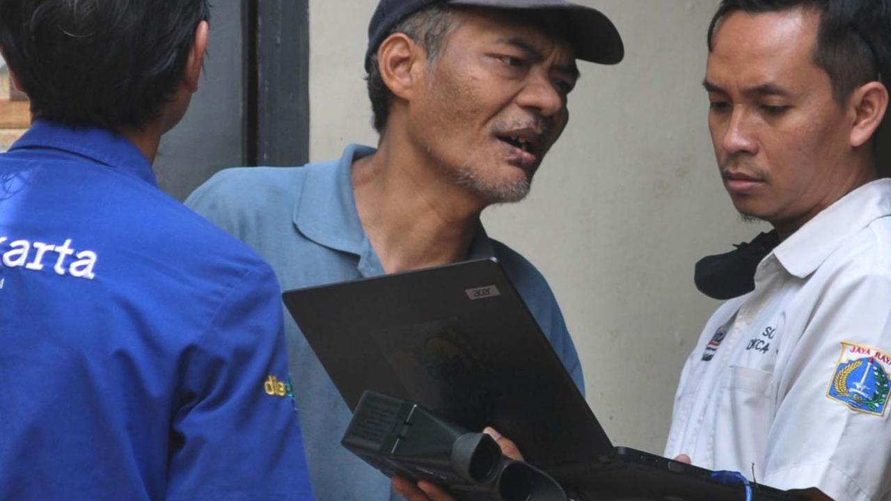 Petugas Dukcapil DKI melakukan perekaman e-KTP terhadap Suradi, warga penyandang disabilitas gangguan jiwa (ODGJ), di Jalan Waru RT004/02, Cilangkap, Jakarta Timur, Rabu (15/5/2024).&nbsp;Foto: Merdeka.com/Imam Buhori