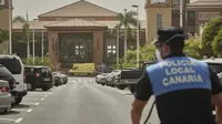 Seorang petugas polisi berdiri di depan hotel H10 Costa Adeje Palace di mana sebuah ambulans diparkir di Tenerife, Canary Island, Spanyol, Selasa, (25/2/2020). Hotel ini diisolasi setelah salah satu kliennya, turis Italia, dinyatakan positif mengalami kontraksi dengan virus corona. (AP Photo)