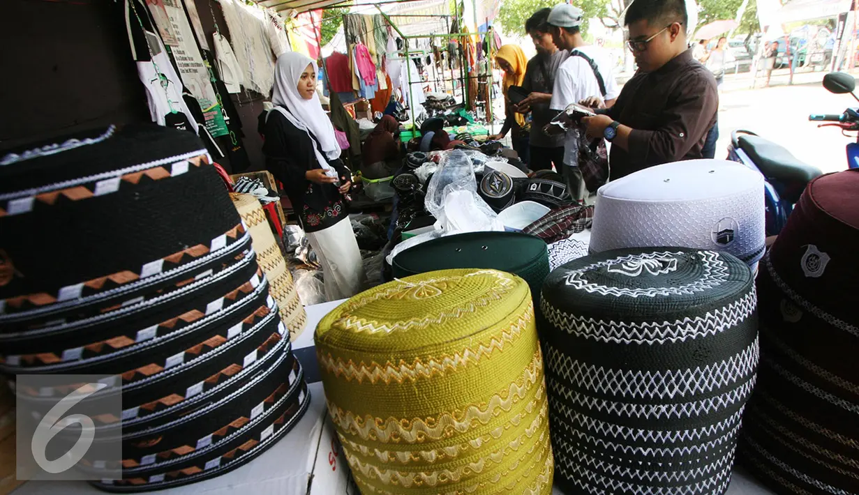 Pengunjung memilih peci yang di tawarkan dengan kisaran harga Rp 5000 hingga Rp 55.000 di halaman masjid Ageng, Solo, Jawa Tengah, Sabtu (25/6). Omzet penjualan pedagang mengalami peningkatan selama bulan ramadan. (Liputan6.com/Boy Harjanto)