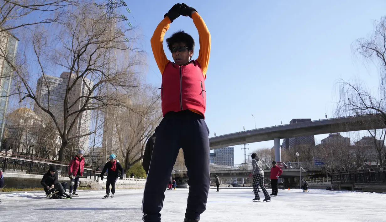 Seorang pria memutar sepatu rodanya di kanal yang membeku saat Olimpiade Musim Dingin 2022 hampir berakhir di Beijing pada Sabtu, 19 Februari 2022. (AP Photo/Ng Han Guan)