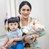 Dalam potret yang dibagikan, salah satu Diva Indonesia itu terlihat begitu bahagia. Tidak hanya bersama si kecil, tapi juga baby Ameena. KD tampak anggun dengan kebaya Jawa motif bunga dan juga dengan kain jarik. [Instagram/krisdayantilemos]