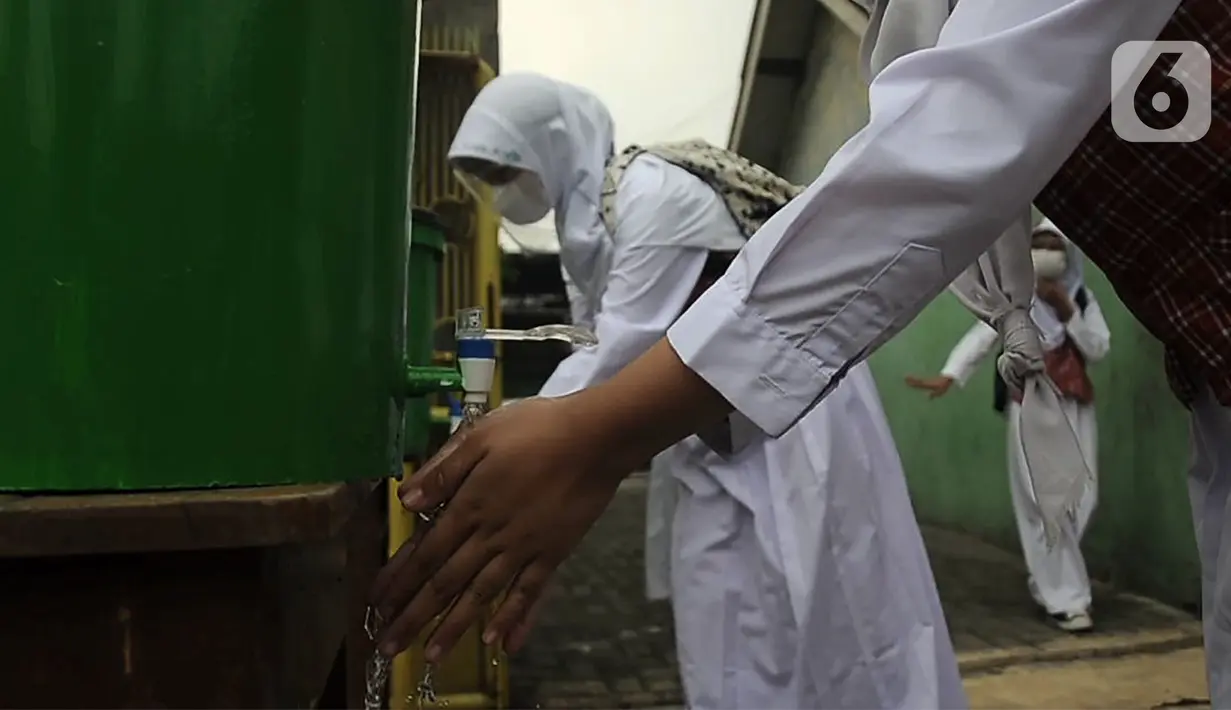 Murid mencuci tangan sebelum memasuki ruang kelas saat pembelajaran tatap muka (PTM) terbatas di SDN Pisangan Baru 05 Pagi, Jakarta, Senin (8/11/2021). Sekolah diwajibkan disiplin menerapkan protokol kesehatan saat kegiatan belajar dan membatasi 50 persen jumlah murid. (merdeka com/Iqbal S. Nugroho)