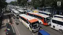 Suasana di Jalan Medan Merdeka Timur saat dipadati puluhan bus yang mengangkut buruh, Jakarta, Selasa (1/5). Memperingati Hari Buruh yang jatuh setiap tanggal 1 Mei, sejumlah organisasi pekerja mengadakan demonstrasi. (Liputan6.com/Arya Manggala)
