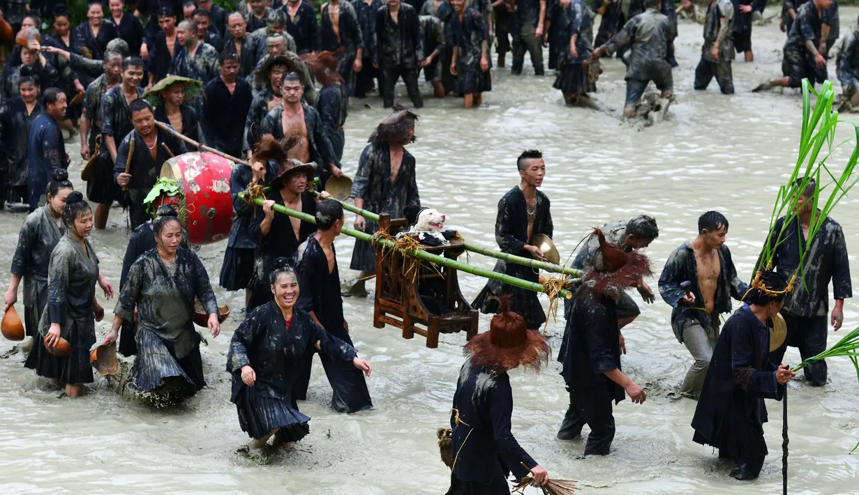 Sekelompok orang dari etnis Miao membawa anjing diletakan di kursi saat festival dog carrying day di provinsi Guizhou, Tiongkok (2/9). Acara ini juga bertujuan memberikan rasa hormat kepada semua makhluk. (AFP Photo/STR/China Out)