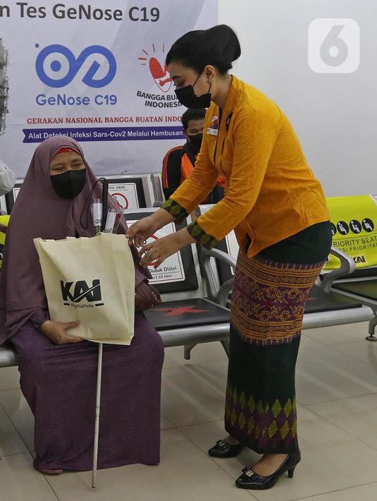 Petugas PT KAI Daop 1 Jakarta berkebaya membagikan bunga dan goodie bag kepada penumpang di Stasiun Gambir, Rabu (21/4/2021). Petugas perempuan itu mengenakan kebaya dan membagikan bunga kepada penumpang guna memeriahkan Hari Kartini yang jatuh pada hari ini. (Liputan6.com/Herman Zakharia)