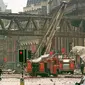 Petugas pemadam kebakaran berjalan di tengah puing-puing di lokasi ledakan bom di pusat Manchester, 180 mil utara London, 15 Juni 1996. (AP)