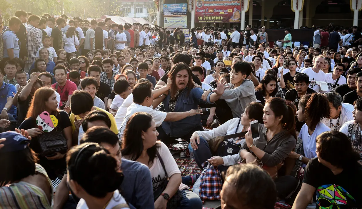 Seorang peserta kesurupan saat mengikuti festival tato suci di Biara Wat Bang Phra, Nakhon Pathom, Thailand (3/3). Tradisi ini merupakan bagian dari festival tahunan Sak Yant yang diadakan setiap bulan Maret. (AFP Photo/Lillian Suwanrumpha)