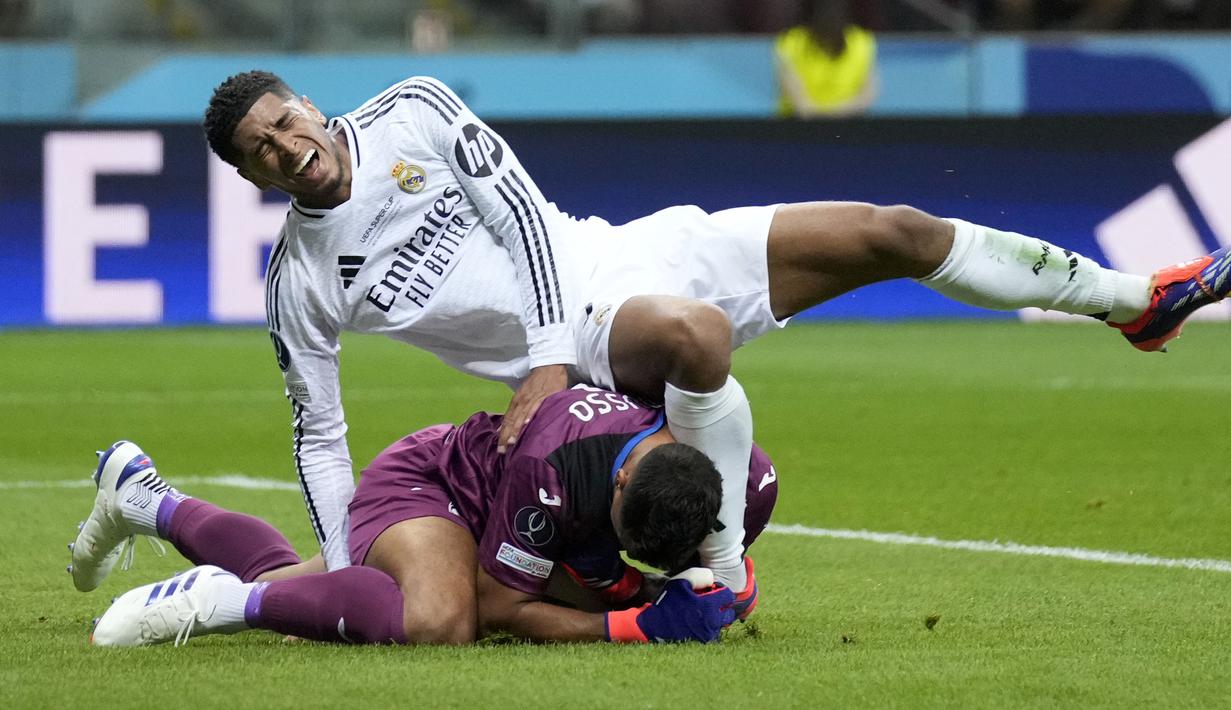 Kiper Atalanta, Juan Musso berhasil mengamankan bola dari ancaman gelandang Real Madrid, Jude Bellingham pada laga Piala Super Eropa 2024 di Narodowy Stadium, Warsawa, Polandia, Rabu (14/8/2024). (AP Photo/Darko Bandic)