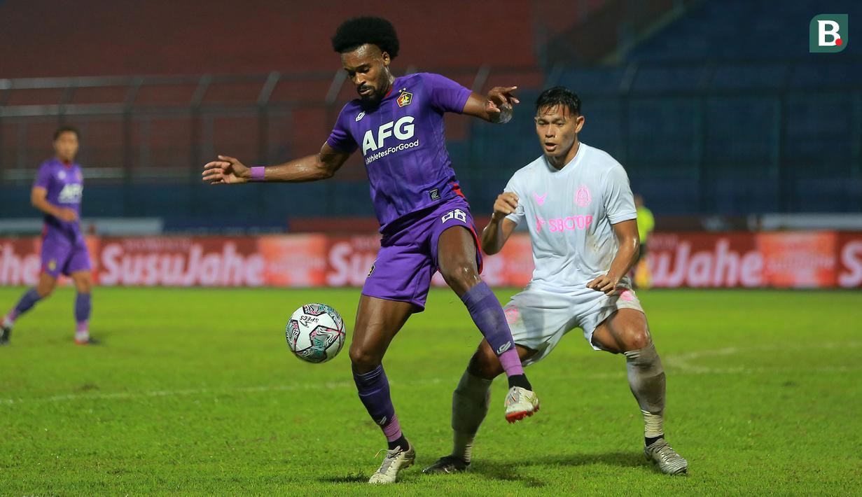 Pemain Persik Kediri, Joanderson De Jesus Assis (kiri), dibayangi pergerakannya oleh Persikabo 1973, Andy Setyo Nugroho (kanan), dalam lanjutan pertandingan babak penyisihan Grup D Piala Presiden 2022 di Stadion Kanjuruhan, Malang, Jawa Timur, Minggu (12/6/2022). (Bola.com/Arief Bagus)